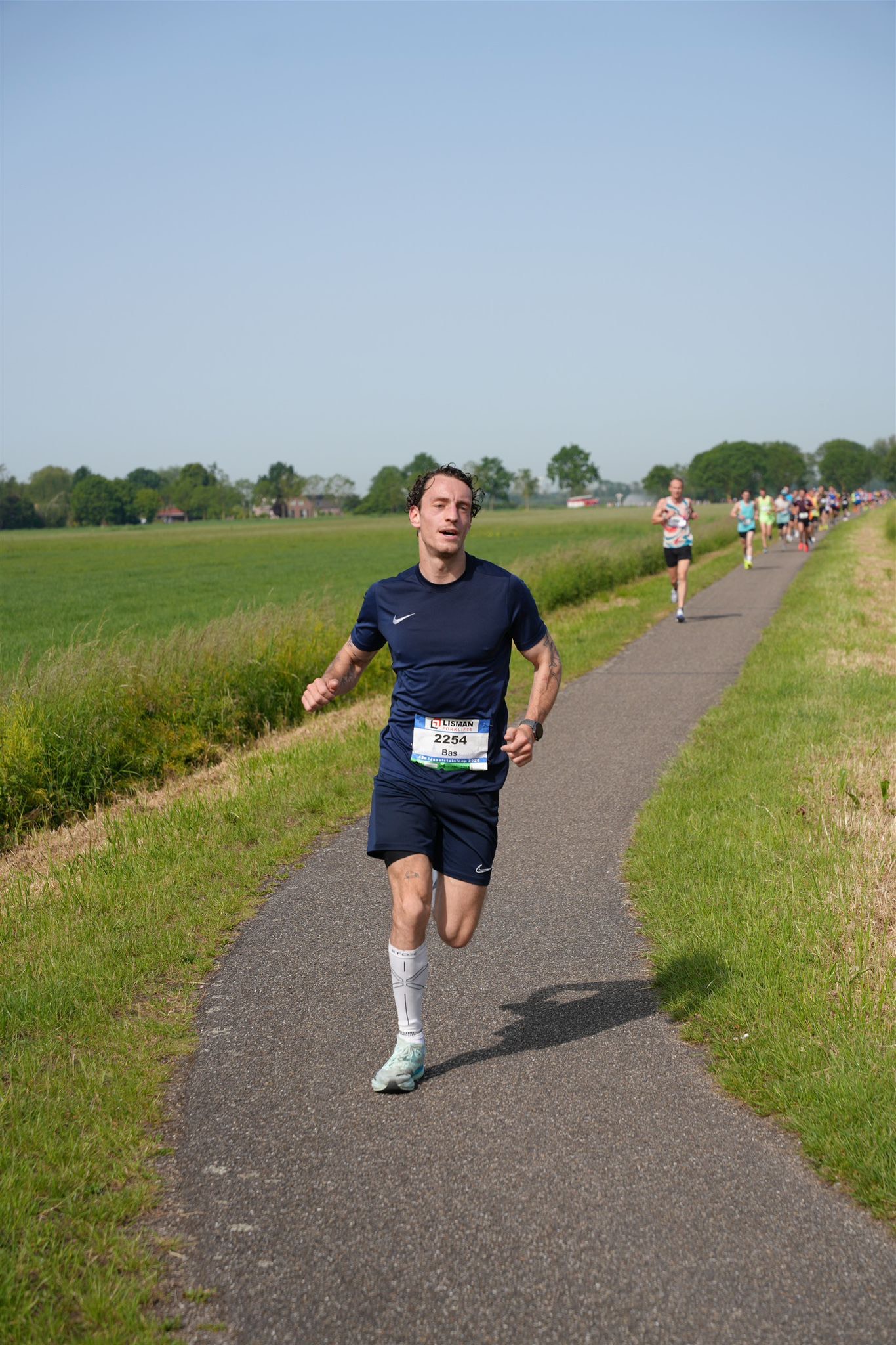 Mastering the First Impression: Your intriguing post title goes here Hardloopcoach Bas Paumen tijdens lokale hardloopwedstrijd